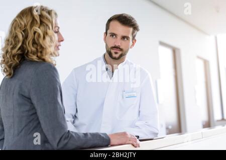 Geschäftsfrau und Arzt im Krankenhaus sprechen Stockfoto