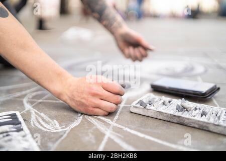 Street Art, Künstler Zeichnung auf Bürgersteig und mit Smartphone Stockfoto