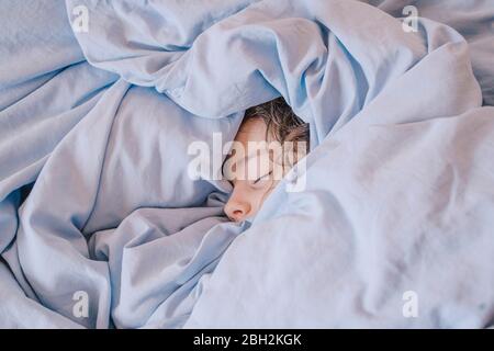 Portrait des schlafenden Mädchens unter der Decke liegend Stockfoto