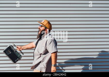 Bärtiger Mann mit tragbarem Radio Stockfoto