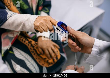 Arzt, der den Puls des Patienten in der medizinischen Praxis nimmt Stockfoto