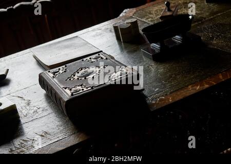 Antik ungeöffnetes großes gebundenes Buch auf einem alten Eichenschreibtisch Tisch in Tageslicht Stockfoto