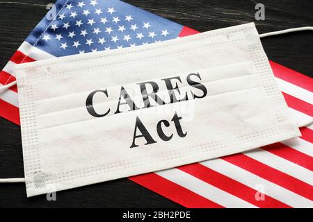 Amerikanische Flagge und Maske mit Schild sorgt handeln. Coronavirus Aid, Relief, and Economic Security Law Concept. Stockfoto