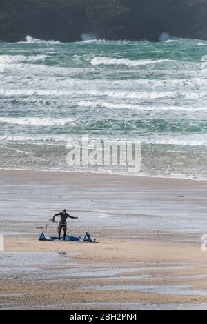 Ein einbeinige Kite-Surfer-Boarder bereitet seine Kiteboarding-Surfausrüstung am Fistral Beach in Newquay in Cornwall vor. Stockfoto