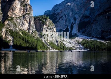 Lago di Prags, Italien - 14. August 2019: Menschen in Booten im Lago di Prags bei Sonnenuntergang Stockfoto