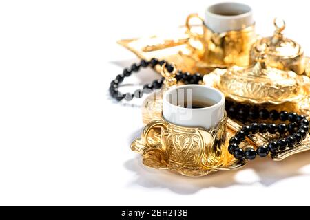 Goldene Kaffeetassen und Rosenkranz Perlen. Islamische Feiertage. Ramadan. Selektiver Fokus Stockfoto
