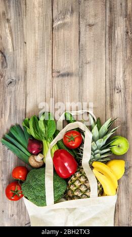 Gemüse und Obst in einem Beutel aus Baumwolle. Tomaten, Gurken, Brokkoli, Ananas, Apfel, banane, Salat Stockfoto