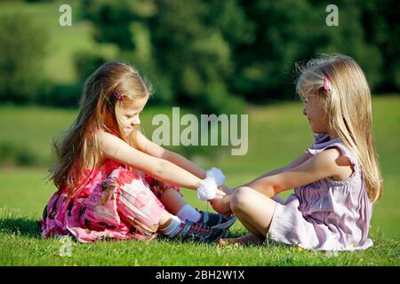 Junge Mädchen Zwillinge spielen im Freien in Lockdown Stockfoto