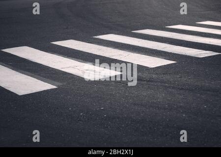 Weiße Querstreifen auf einer Straße in der Stadt. Verkehrssicherheit, verkehrsberuhende Maßnahmen. Stockfoto