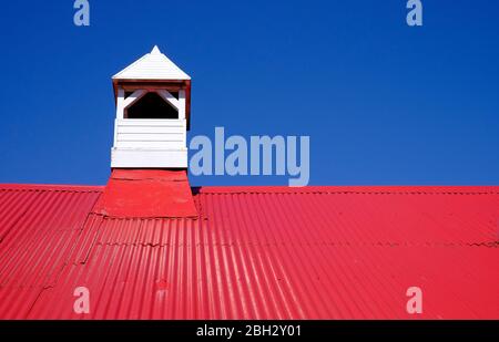 Rot lackiertes Wellblech Dach und blauer Himmel Hintergrund Stockfoto