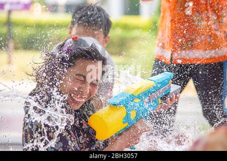 Asiatische Frau mit einer Wasserpistole spielen Songkran Festival oder Thai Neujahr in Thailand. Stockfoto