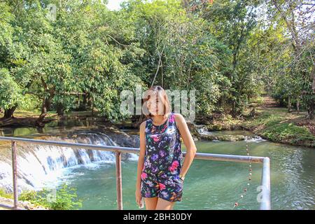 Asean-Frau und Wasser in den strom ist grün und leuchtend grünen Baum bei Kapo Wasserfall Fores Park, Chumphon in Thailand. Stockfoto