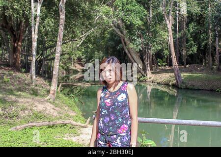 Asean-Frau und Wasser in den strom ist grün und leuchtend grünen Baum bei Kapo Wasserfall Fores Park, Chumphon in Thailand. Stockfoto