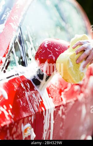 Frau, die ihr Auto waschen Stockfoto