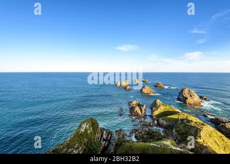 Atemberaubende Landschaft am Nugget Point, einem der markantesten Orte an der Küste von Otago in Neuseeland. Es verfügt über eine steile Landzunge und einen Leuchtturm. Stockfoto