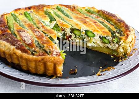 Tarte mit grünem Spargel und geröstetem Käse auf dem Tisch Stockfoto