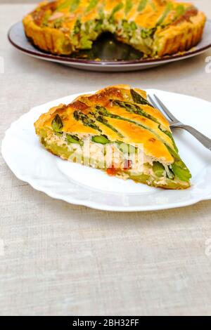 Scheibe Tart mit grünem Spargel und geröstetem Käse auf dem Tisch in Scheiben geschnitten Stockfoto