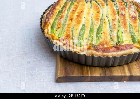 Tarte mit grünem Spargel und geröstetem Käse auf dem Tisch Stockfoto