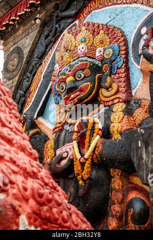 Ein kleiner Freiluftschrein ist der schrecklichen Gottheit Kala Bhairava, einer Manifestation Shivas, auf dem Durbar Square in Kathmandu gewidmet Stockfoto