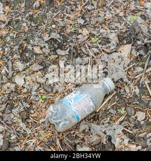 Leere Flasche mit alkoholfreien Getränken auf der Seite der ruhigen Landstraße. Beispiel für Plastikverschmutzung in Großbritannien, Plastik-Einwegmüll, Plastikmüll Stockfoto