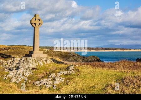 Das Keltenkreuz auf der Insel Llanddwyn mit Snowdonia im Hintergrund, Anglesey Stockfoto