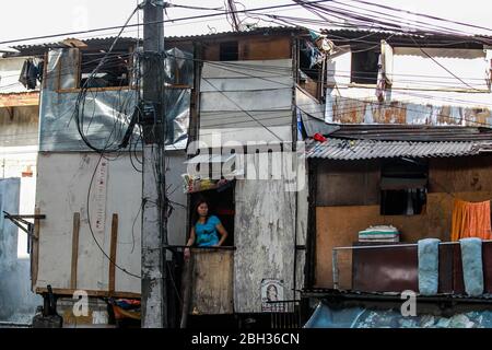 Quezon City. April 2020. Eine Anwohnerin blickt aus dem Fenster ihres Bettshahns auf ein Slumgebiet in Quezon City, Philippinen, am 23. April 2020. Quelle: Rouelle Umali/Xinhua/Alamy Live News Stockfoto