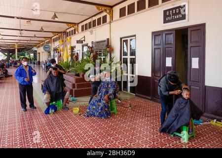 Friseur mit Gesichtsmasken im Bahnhof in Ayutthaya, Thailand Stockfoto