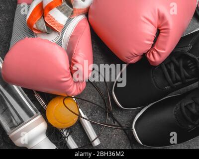 Sport-Sneaker, Leder Boxhandschuhe, Springseil, Tennisball, Flasche Wasser, Frauen Boxkonzept Stockfoto