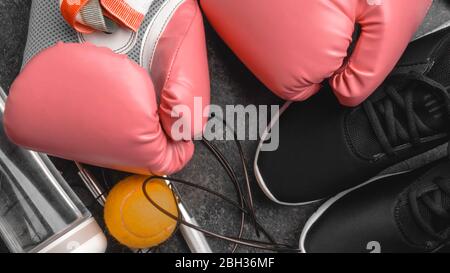 Sport-Sneaker, Leder Boxhandschuhe, Springseil, Tennisball, Flasche Wasser, Frauen Boxkonzept Stockfoto