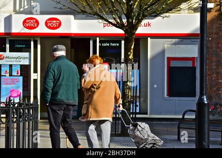 Ein älteres Paar geht am Haupteingang des Postgebäudes in der Wyndham Street im Stadtzentrum von Bridgend vorbei. Stockfoto