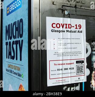 Ein Greggs Bäckerei Schild neben einem Hilfe und Beratung Poster, die Informationen, wo man Hilfe während dieser Covid-19 und Coronavirus Pandemie, die tobt obwohl Großbritannien zu bekommen. Das ganze Land ist in der Blockierung. Glasgow. April 2020. ALAN WYLIE/ALAMY© Stockfoto