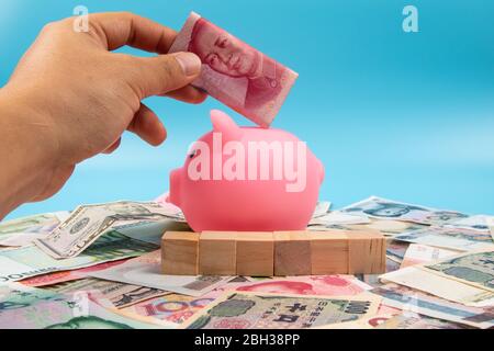 Sparschwein- und Weltbanknoten-Sammlung gemischt auf Tisch, Draufsicht. Geschäfts- und Finanzkonzept. Stockfoto