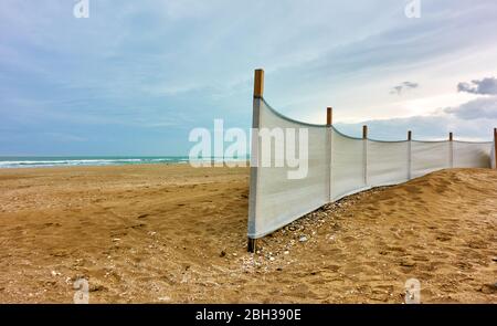 Blick auf den Sandstrand mit Stoffzaun in Rimini, Italien. Italienische Landschaft - Seenlandschaft Stockfoto