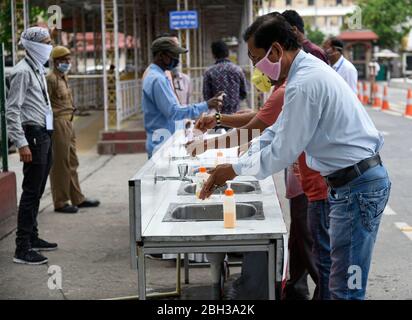 Guwahati, Assam, Indien. 21. April 2020. Mitarbeiter desinfizieren ihre Hände, bevor sie in ein Büro gehen, um ihre Pflicht zu erfüllen, inmitten der COVID-19-Sperre in Guwahati. Foto: David Talukdar Stockfoto