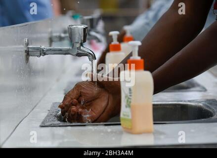 Guwahati, Assam, Indien. 21. April 2020. Mitarbeiter desinfizieren ihre Hände, bevor sie in ein Büro gehen, um ihre Pflicht zu erfüllen, inmitten der COVID-19-Sperre in Guwahati. Foto: David Talukdar Stockfoto