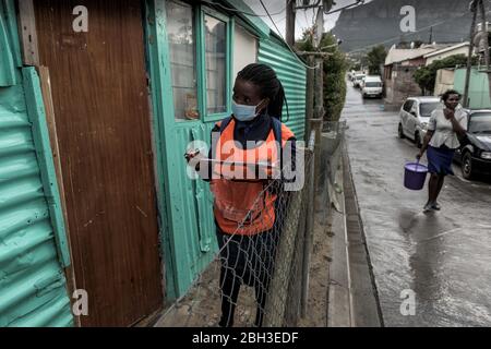 Südafrikanische Gesundheitshelfer in der dicht besiedelten informellen Siedlung Hout Bay in Imizamo Yethu bei Kapstadt, die nach Coronavirus screenen Stockfoto