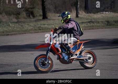 23-04-2020 Riga, Lettland. Professionelle Motocross Motorrad Rider fährt durch zivile Straße Stockfoto