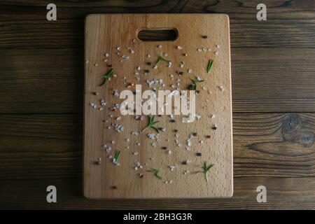Alte abgenutzte, rissige und zerkratzte Holzschneidebrett. Mit Gewürzen bestreut. Von oben mit viel Platz Stockfoto