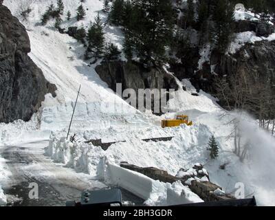 Ausrüstung zur Schneeräumung entlang der kurvenreichen Straße zur Sonne auf einer Höhe von 6,646 Fuß im Glacier National Park 21. April 2020 in Glacier, Montana. Die Straßenräumung geht weiter, obwohl der Park wegen der COVID-19, einer Coronavirus-Pandemie, für Besucher gesperrt ist. Stockfoto