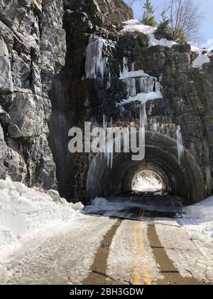 Der West Side Tunnel wurde jetzt auf der gewundenen Straße zur Sonne auf einer Höhe von 6,646 Fuß im Glacier National Park am 14. April 2020 in Glacier, Montana, von Schnee befreit. Die Straßenräumung geht weiter, obwohl der Park wegen der COVID-19, einer Coronavirus-Pandemie, für Besucher gesperrt ist. Stockfoto