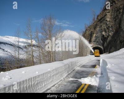 Schneeräumgeräte am West Side Tunnel entlang der gewundenen Straße zur Sonne auf einer Höhe von 6,646 Fuß im Glacier National Park 14. April 2020 in Glacier, Montana. Die Straßenräumung geht weiter, obwohl der Park wegen der COVID-19, einer Coronavirus-Pandemie, für Besucher gesperrt ist. Stockfoto