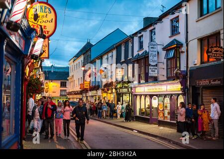 Killarney, Irland - 16. März 2018: Menschen, die in der Abenddämmerung durch die belebten Straßen von Killarney gehen. Killarney ist ein beliebtes landschaftlich reizvoller Touristenziel in Stockfoto