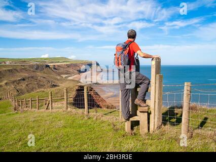 Männlicher Wanderer überquert den Cleveland Way National Trail zwischen Skinningrove und Staithes, North Yorkshire, England, Großbritannien Stockfoto