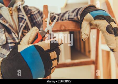 Nahaufnahme Von Elelktriker Auf Leiter Und Abisolierwerkzeug Für Die Kabelisolierung. Stockfoto