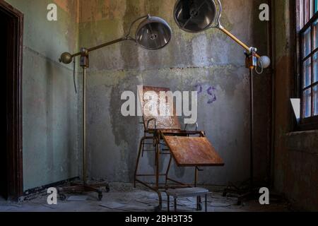 Operationsbett und Lampen in einem verlassenen Krankenhaus Stockfoto