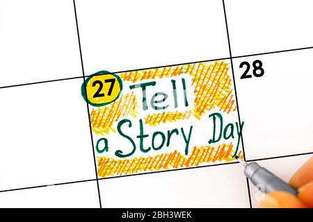 Frau Finger mit Stift Schreiben Erinnerung erzählen eine Geschichte Tag im Kalender. April 27. Stockfoto