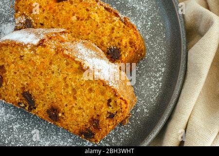 Zwei Stück Karottenkuchen mit Rosinen auf grauem Teller Stockfoto