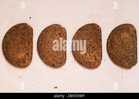 Vier Scheiben Brot auf Papier. Leckeres Brot in Scheiben geschnitten Stockfoto