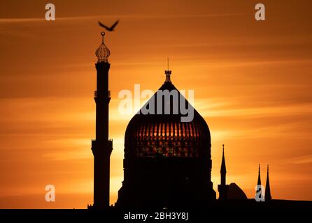 Dresden, Deutschland. April 2020. Die Sonne geht hinter der ehemaligen Dresdner Zigarettenfabrik Jenidze unter, die 1909 im Stil einer 62 Meter hohen Moschee errichtet wurde. Quelle: Sebastian Kahnert/dpa-Zentralbild/dpa/Alamy Live News Stockfoto