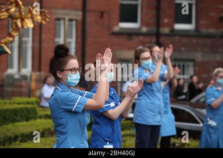 Krankenhausmitarbeiter außerhalb des Leeds General Infirmary grüßen lokale Helden während der landesweiten Initiative „Clap for Carers“ am Donnerstag, um NHS-Mitarbeiter und Betreuer zu unterstützen, die gegen die Coronavirus-Pandemie kämpfen. Stockfoto